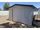 A white detached garage with a closed door in the backyard of this home at 903 W Jacinto Cir, Mesa, AZ 85210