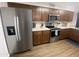 Kitchen with stainless steel refrigerator, microwave, and oven, paired with brown cabinets and white countertops at 903 W Jacinto Cir, Mesa, AZ 85210