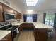 Well-lit kitchen featuring updated appliances, wood cabinets, and a large island with barstool seating at 903 W Jacinto Cir, Mesa, AZ 85210