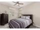 Bedroom featuring a ceiling fan, a large window, and a striped bedspread at 9325 W Montecito Ave, Phoenix, AZ 85037
