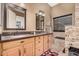 A well-lit bathroom with dual sinks, stone accent wall, and modern fixtures at 10529 E Posada Ave, Mesa, AZ 85212
