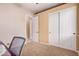 This carpeted bedroom is currently being used as an office and features a view of the hallway at 10529 E Posada Ave, Mesa, AZ 85212