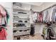 Walk-in closet boasts built-in shelving for folded clothes, shoes, and hanging space for shirts, dresses, and pants at 10529 E Posada Ave, Mesa, AZ 85212