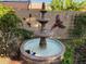 Charming backyard fountain with decorative wall art and lush landscaping creates a serene outdoor oasis at 10529 E Posada Ave, Mesa, AZ 85212