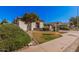 Lovely single-story home showcasing desert landscaping, a green lawn and a two-car garage at 10529 E Posada Ave, Mesa, AZ 85212