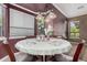 A kitchen eat-in area with a round table lit by a decorative lighting fixture, with multiple windows at 10529 E Posada Ave, Mesa, AZ 85212