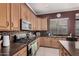 A kitchen boasts light wood cabinets, stainless steel appliances, and a stone backsplash for a sleek design at 10529 E Posada Ave, Mesa, AZ 85212