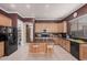 A kitchen island complements light wood cabinets and stainless steel appliances, complete with stone countertops at 10529 E Posada Ave, Mesa, AZ 85212
