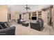 Spacious living room featuring comfortable seating, carpet flooring, a ceiling fan, and built-in shelving at 10529 E Posada Ave, Mesa, AZ 85212