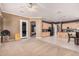 A spacious living room featuring neutral-toned walls and flooring, open to a kitchen with light wood cabinetry at 10529 E Posada Ave, Mesa, AZ 85212