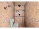 Walk-in shower features a tiled surround, rainfall shower head, mosaic accents, and built-in niche with seating at 10529 E Posada Ave, Mesa, AZ 85212