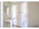 Powder bathroom featuring a white pedestal sink and round mirror at 12408 W Orange Dr, Litchfield Park, AZ 85340