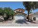Two story home featuring a driveway, two car garage, desert landscaping, and a red tile roof at 12408 W Orange Dr, Litchfield Park, AZ 85340