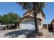 Two story home featuring a driveway, two car garage, desert landscaping, and a red tile roof at 12408 W Orange Dr, Litchfield Park, AZ 85340