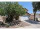 Two story home featuring a driveway, two car garage, desert landscaping with rock features, and a red tile roof at 12408 W Orange Dr, Litchfield Park, AZ 85340