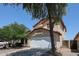 Two story home featuring a driveway, two car garage, desert landscaping, and a red tile roof at 12408 W Orange Dr, Litchfield Park, AZ 85340