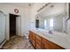 Main bathroom with dual sinks and large mirror plus shower at 12408 W Orange Dr, Litchfield Park, AZ 85340