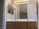 Bathroom with double sinks, a large vanity mirror, and decorative lighting at 12425 W Montebello Ave, Litchfield Park, AZ 85340