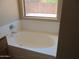 Soaking tub in the bathroom area with a bright window view to the backyard at 12425 W Montebello Ave, Litchfield Park, AZ 85340