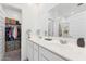 Bright bathroom featuring a double sink vanity with white cabinets and a large mirror at 12672 W Marguerite Ave, Avondale, AZ 85323