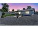 Charming backyard with gravel landscaping, a covered patio, mature trees, and a lush green lawn at 13224 N 31St Pl, Phoenix, AZ 85032