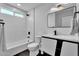 Modern bathroom featuring a sleek vanity, black fixtures, geometric tiled wall, and a combined tub and shower at 13224 N 31St Pl, Phoenix, AZ 85032