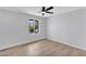 Bright bedroom with neutral walls, wood-look floors, a ceiling fan, and a window overlooking the yard at 13224 N 31St Pl, Phoenix, AZ 85032
