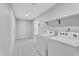 Bright laundry room featuring modern washer and dryer appliances, geometric tiled floors, and neutral walls at 13224 N 31St Pl, Phoenix, AZ 85032
