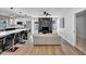 Open-concept living area featuring a modern fireplace, hardwood floors, and an adjacent kitchen with a breakfast bar at 13224 N 31St Pl, Phoenix, AZ 85032