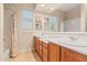 Bright bathroom featuring dual sinks with cherry cabinets and vanity along with shower and tub at 14333 W Alvarado Dr, Goodyear, AZ 85395