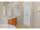 Bright bathroom showcasing a glass enclosed shower, vanity with cherry cabinet, and tile flooring at 14333 W Alvarado Dr, Goodyear, AZ 85395