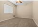 Neutral bedroom with carpet flooring, ceiling fan, and a window at 14333 W Alvarado Dr, Goodyear, AZ 85395