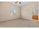 Bedroom featuring an arched window, carpet, and a view into the bathroom at 14333 W Alvarado Dr, Goodyear, AZ 85395