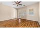 Inviting bedroom with hardwood floors, ceiling fan, and a private door, creating a comfortable living space at 14333 W Alvarado Dr, Goodyear, AZ 85395
