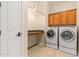Well-equipped laundry room with washer, dryer, cabinets, and counter space at 14333 W Alvarado Dr, Goodyear, AZ 85395