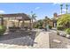Backyard featuring a pergola with an outdoor fireplace, fountain, and lush landscaping at 1449 W Sherri Dr, Gilbert, AZ 85233