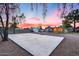 Large concrete backyard basketball court with a view of house with string lights, shed, and ample space at 16437 N 61St Ave, Glendale, AZ 85306