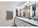 Bathroom featuring double sinks, large mirror, and decorative fixtures at 16437 N 61St Ave, Glendale, AZ 85306