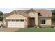 Inviting single-story home showcasing a charming front yard, neutral-toned stucco, and a convenient two-car garage at 17363 W Fallen Leaf Ln, Surprise, AZ 85387