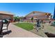 Landscaped backyard with artificial turf, water feature, and patio area at 1753 Leisure World --, Mesa, AZ 85206