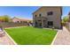 Spacious backyard with artificial green grass, a patio, and plenty of room for outdoor enjoyment at 17560 W Young St, Surprise, AZ 85388