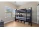 Bright bedroom with a modern bunk bed, wood flooring, and natural light from the windows at 17560 W Young St, Surprise, AZ 85388