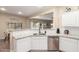 Well-lit kitchen area featuring white cabinets, stainless steel appliances, and granite countertops at 17560 W Young St, Surprise, AZ 85388