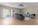 Inviting living room with light wood floors, a ceiling fan, and sliding glass doors to the backyard at 17560 W Young St, Surprise, AZ 85388