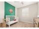 Bright Bedroom featuring a crib, green accent wall, and charming decor at 19595 W San Miguel Ave, Litchfield Park, AZ 85340