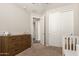Bedroom featuring a white crib, a dresser and plush carpeting at 19595 W San Miguel Ave, Litchfield Park, AZ 85340