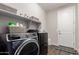 Efficient laundry room with modern washer, dryer, shelving, and ample storage, enhancing convenience at 19595 W San Miguel Ave, Litchfield Park, AZ 85340