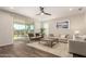 Bright living room with a sliding glass door, neutral furniture, and wood-look floors at 19595 W San Miguel Ave, Litchfield Park, AZ 85340