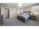 Calming, spacious bedroom with a gray finishings, bedside tables, and an arched doorway to the ensuite bathroom at 20699 W Ridge Rd, Buckeye, AZ 85396