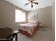 This cozy bedroom features a ceiling fan, neutral walls, and a comfortable bed with a floral duvet cover at 20699 W Ridge Rd, Buckeye, AZ 85396